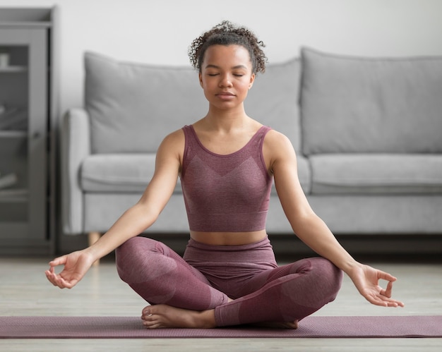 Gratis foto fitness vrouw doet yoga op een yogamat thuis