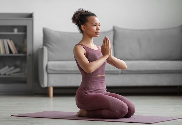 Gratis foto fitness vrouw doet yoga op een yogamat thuis