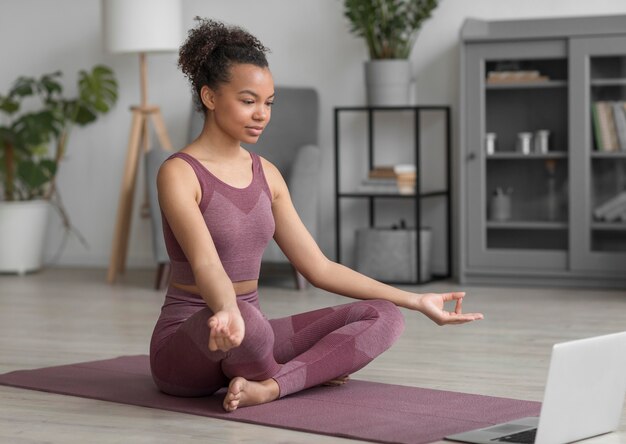 Fitness vrouw doet yoga op een yogamat thuis