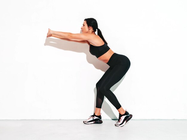 Fitness zelfverzekerde vrouw in sportkleding Sexy jonge mooie model met perfect lichaam Vrouw poseren in studio die zich uitstrekt voor de training
