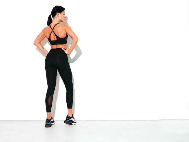 Fitness zelfverzekerde vrouw in sportkleding Sexy jonge mooie model met perfect lichaam Vrouw poseren in studio die zich uitstrekt voor de training
