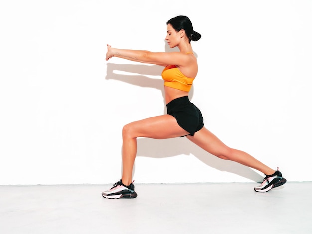 Fitness zelfverzekerde vrouw in sportkleding Sexy jonge mooie model met perfect lichaam Vrouw poseren in studio die zich uitstrekt voor de training