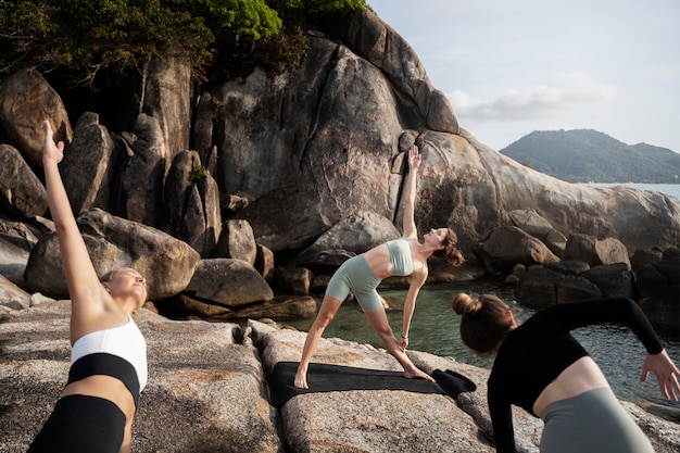 Fitte vrouwen die yoga doen in de natuur