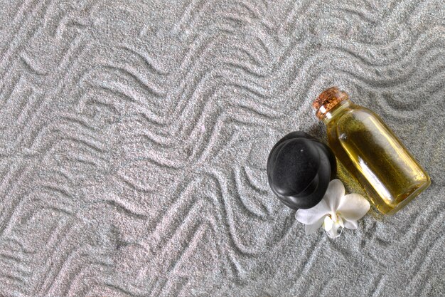 Fles olie en zwarte steen op handdoek