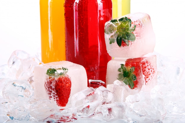 Flessen met kleurrijke cocktail en ijs