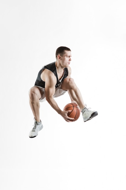 Flexibele basketbalspeler het passeren van de bal tussen zijn benen