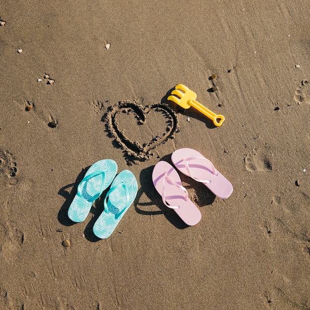 Gratis foto flip flops in het zand op het strand