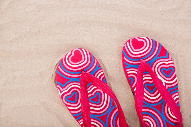 Gratis foto flip flops op zandstrand