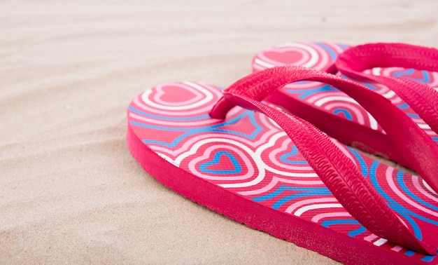 Gratis foto flip flops op zandstrand