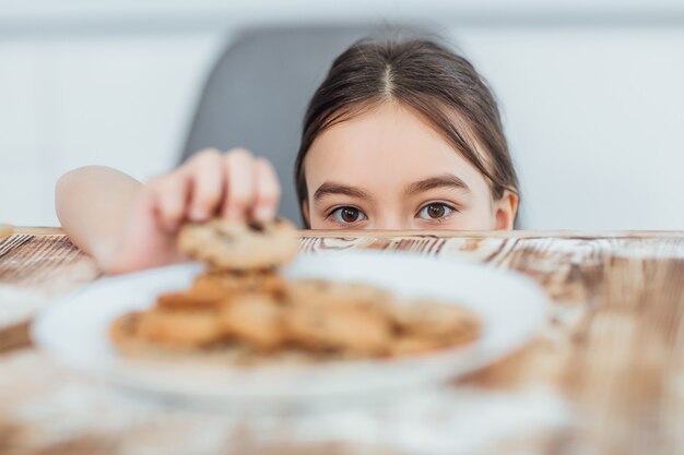 Focus op klein meisje steelt koekje