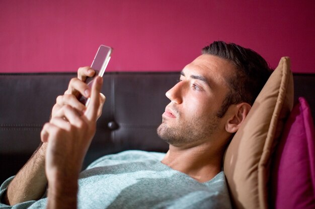 Focused Man Met Smartphone Op De Sofa In Avond