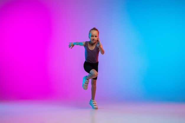 Folder. Tienermeisje, professionele hardloper, jogger in actie, beweging geïsoleerd op gradiënt roze-blauw