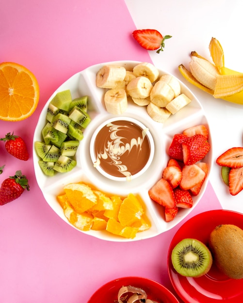 Gratis foto fondue met chocolade, kiwi, aardbei, banaan en sinaasappel