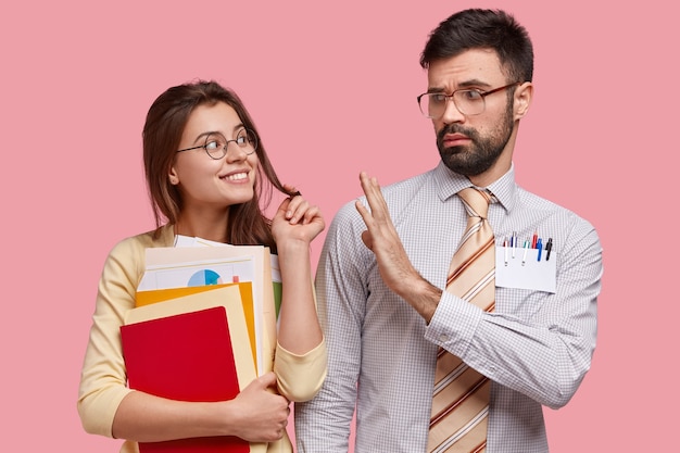 Foto van aantrekkelijke vrouw flirt met haar jonge leraar, draagt papieren en blocnote