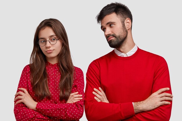 Foto van aantrekkelijke vrouw heeft droevige uitdrukking, lang haar, houdt de armen over elkaar