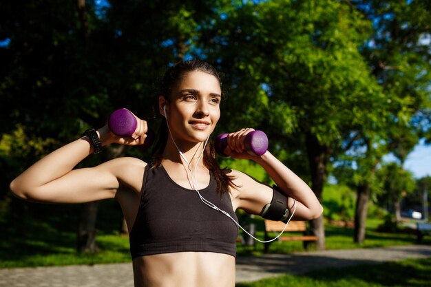 Foto van een jong, aantrekkelijk fitnessmeisje met halters