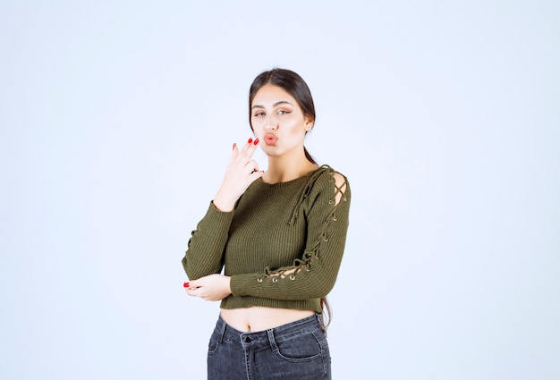 Foto van een jong mooi vrouwenmodel dat kus geeft aan voorzijde