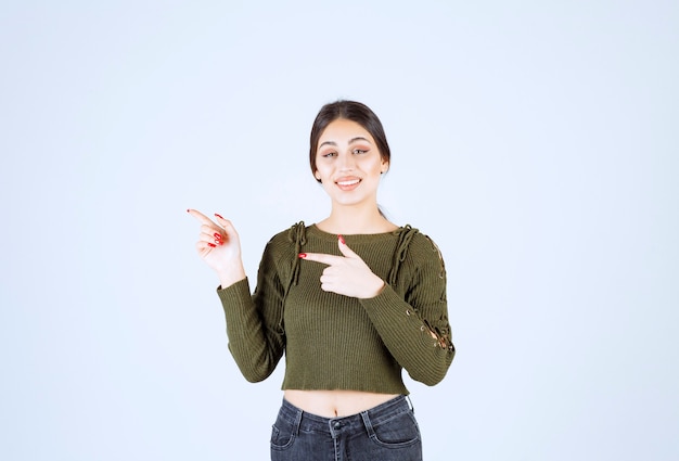 Foto van een jong vrouwenmodel dat en met wijsvinger opzij wijst