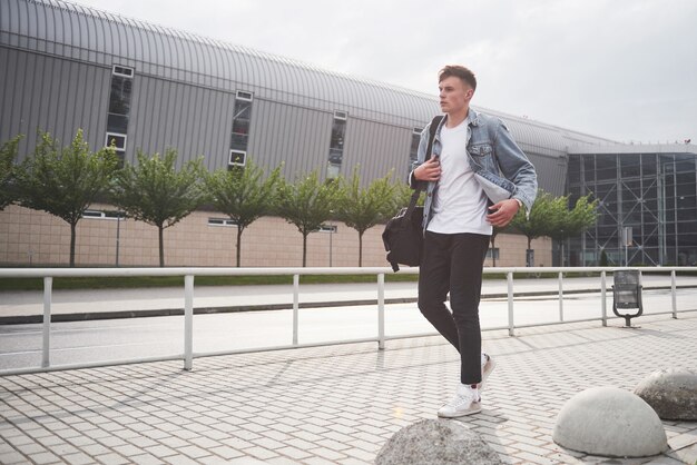 Foto van een jonge man voor een spannende reis op de luchthaven.