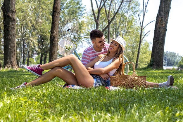 Foto van een mooi stel dat aan het picknicken is in het park