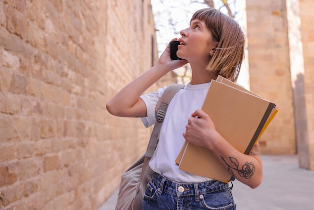 Foto van een mooie vrouw die opkijkt met een mobiele telefoon