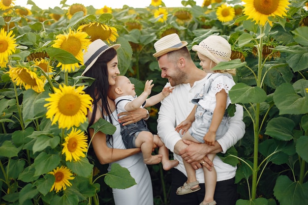 Foto van gelukkige familie. Ouders en dochter. Familie samen op zonnebloemgebied. Man in een wit overhemd.