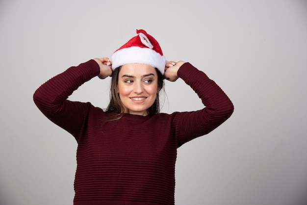 Foto van jonge vrouw in kerstmuts poseren.