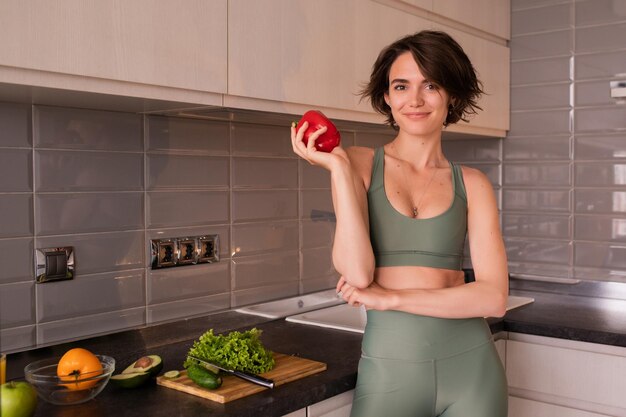 Foto van jonge vrouw met groenten in de keuken