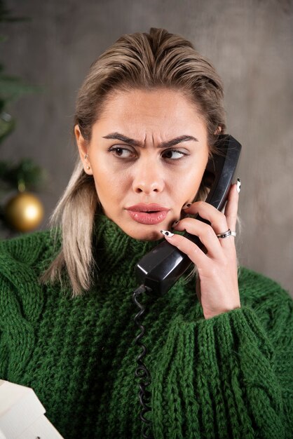 Foto van jonge vrouw praten over een zwarte telefoon