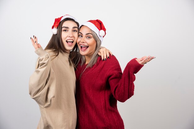 Foto van lachende twee dames vrienden staan en knuffelen.