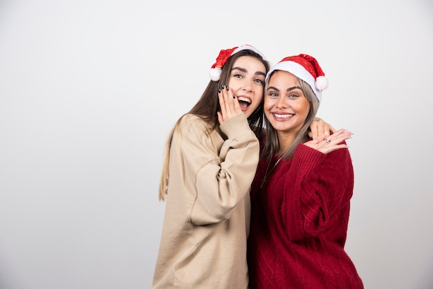 Foto van lachende twee dames vrienden staan en knuffelen.