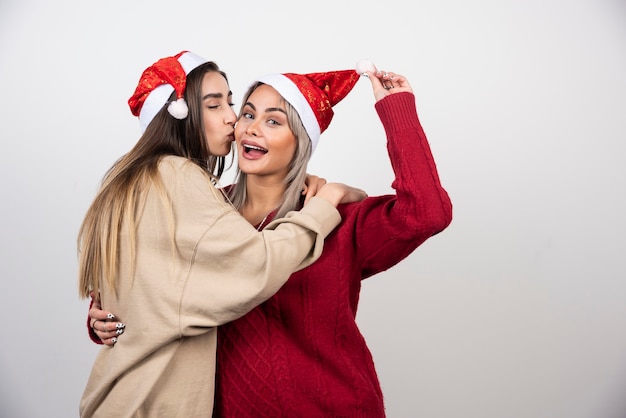 Foto van lachende twee dames vrienden staan en knuffelen.