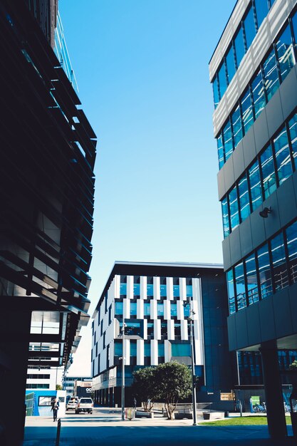 Foto van moderne wolkenkrabbers met blauwe ramen en een parkeerplaats onder een blauwe hemel