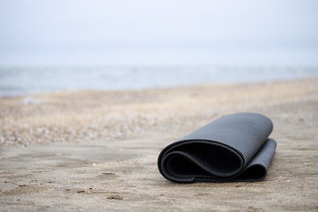 Foto van opgerolde yogamat op het strand Foto van hoge kwaliteit