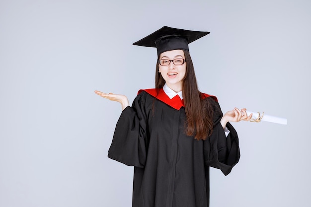 Foto van slimme student in glazen die afstuderen met diploma viert. Hoge kwaliteit foto