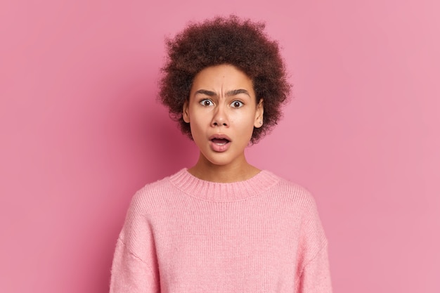 Foto van verbaasd verrast afro-amerikaanse vrouw staart naar de camera met grote verwondering en ongeloof houdt de mond open