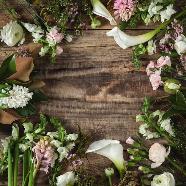 Gratis foto frame van bloemen op houten achtergrond