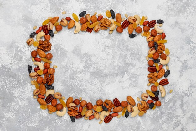 Frame van verschillende noten, Cashewnoten, hazelnoten, walnoten, pistache, pecannoten, pijnboompitten, pinda, rozijnen. Bovenaanzicht