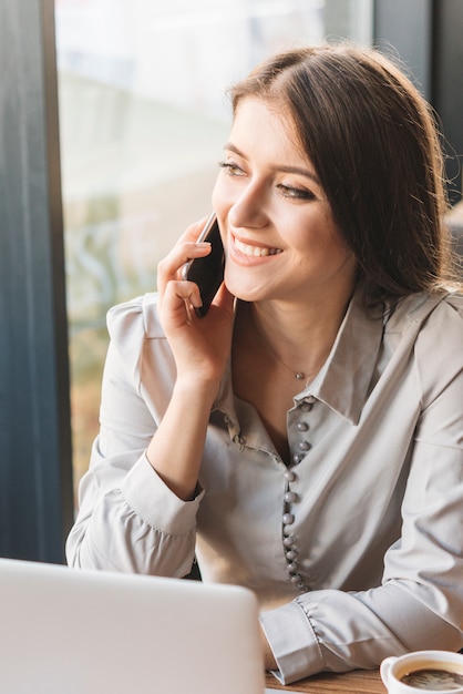 Freelance vrouw die met laptop in koffiewinkel werkt