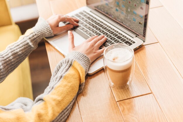 Freelance vrouw die met laptop in koffiewinkel werkt