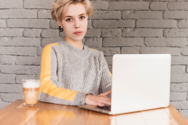 Freelance vrouw die met laptop in koffiewinkel werkt