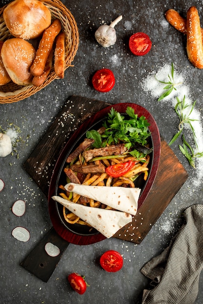 Frieten met stukken gebraden vlees in een kleipot