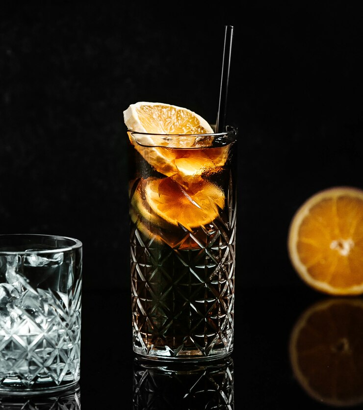 Frisdrank in zwart glas met schijfje citroen
