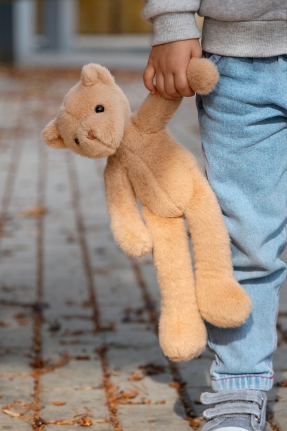 Gratis foto front view kind met een teddybeer buiten