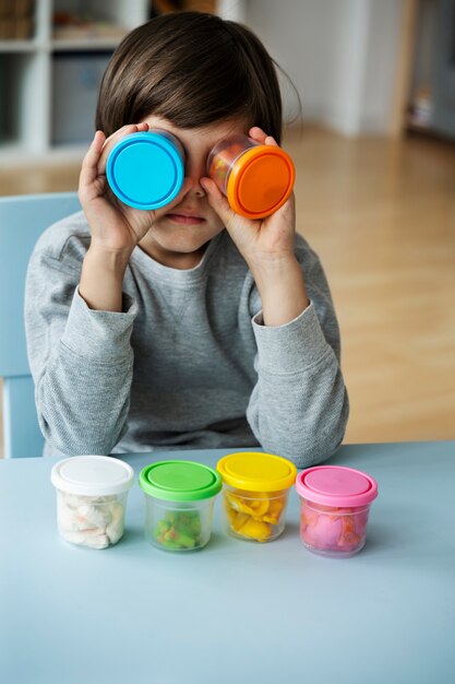 Front view kind speelt met playdough binnen