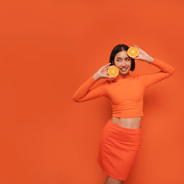 Gratis foto front view vrouw poseert met oranje outfit