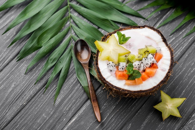 Gratis foto fruitsalade in de hoge mening van de kokosnotenplaat