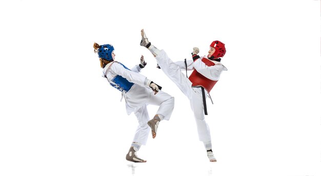 Full-length portret van twee professionele taekwondo feale atleten vechten geïsoleerd op witte achtergrond