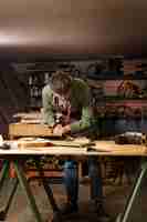 Gratis foto full shot ambachtsman die houtsnijwerk doet