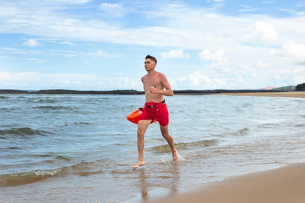 Gratis foto full shot badmeester loopt op het strand